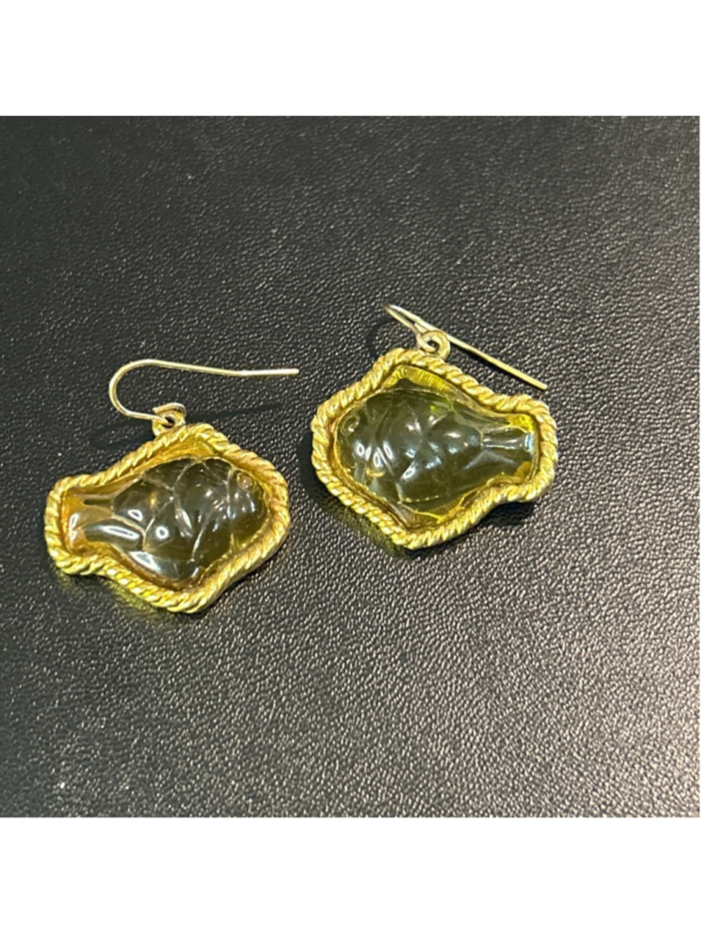 These are vintage Trifari dangle earrings featuring carved green resin